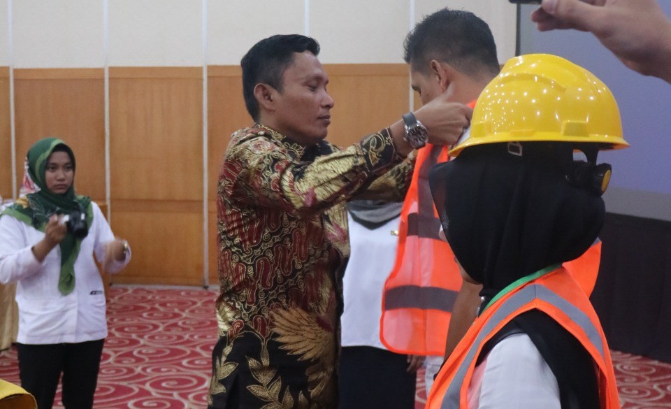 Kadis PUPR Padang Pariaman,Deni sedang mengenakan Rompi keselamatan kerja pada peserta Bimtek